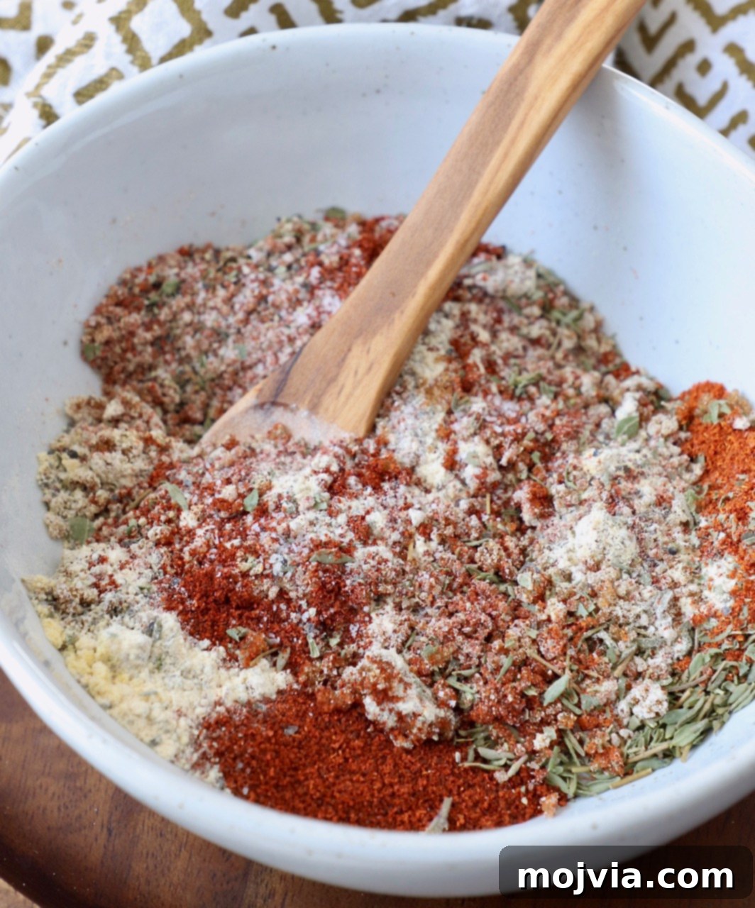 Ultimate Pork Chop Rub 2 A vibrant bowl of homemade pork chop seasoning blend with a wooden spoon, ready to infuse flavor.