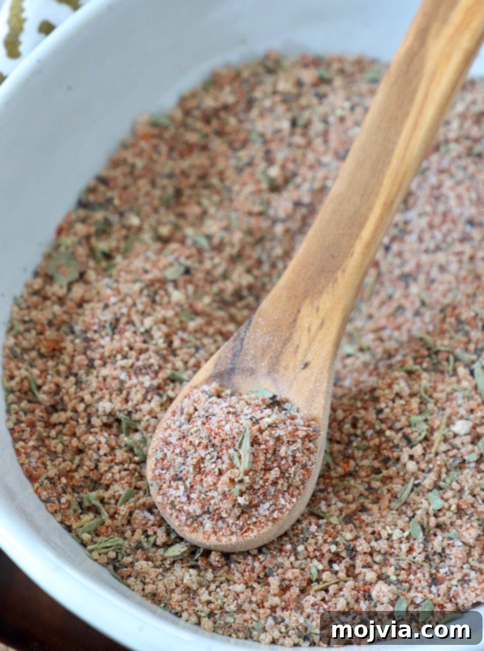 Ultimate Pork Chop Rub 5 A bowl of rich brown sugar pork chop seasoning with a wooden spoon, showcasing its fine texture and readiness for use.