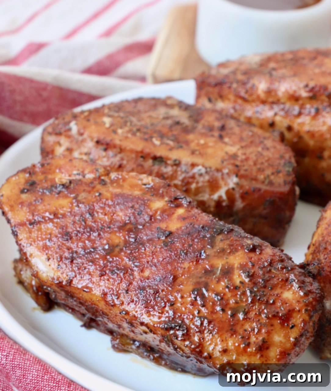 Ultimate Pork Chop Rub 6 Perfectly smoked pork chops on a plate, showcasing a beautiful crust and juicy interior, seasoned with the homemade blend.