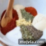 Ultimate Pork Chop Rub 8 herbs and spices in white bowl with spoon