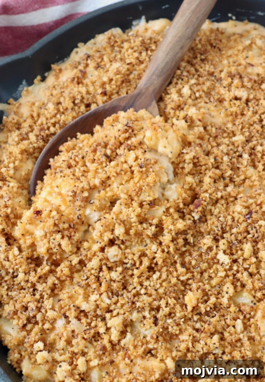 Velvet Smoke Mac 17 serving spoon in skillet of smoked mac and cheese