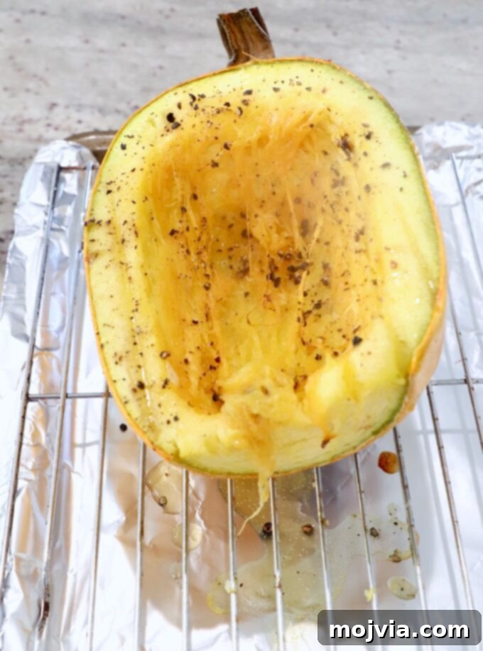 roasted spaghetti squash half sitting on wire rack on top of a baking sheet