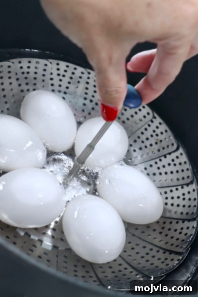 Hand carefully lowering eggs in a steamer basket into a pot of boiling water