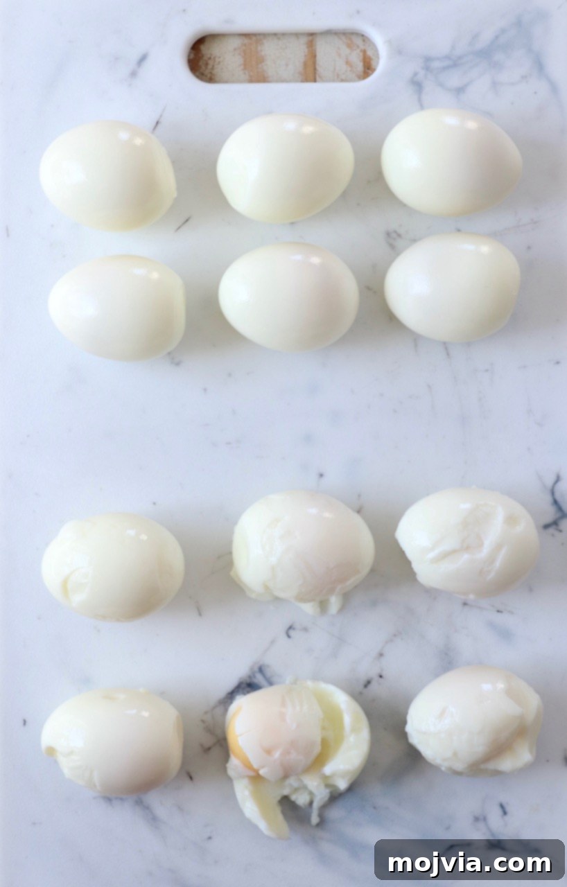 Peeled hard-boiled eggs neatly arranged on a wooden cutting board