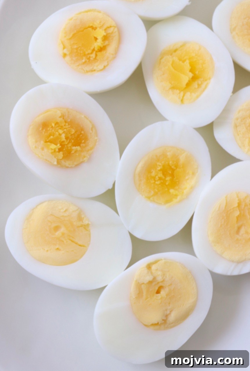 Hard-boiled eggs sliced in half and arranged on a plate, ready for serving or further preparation