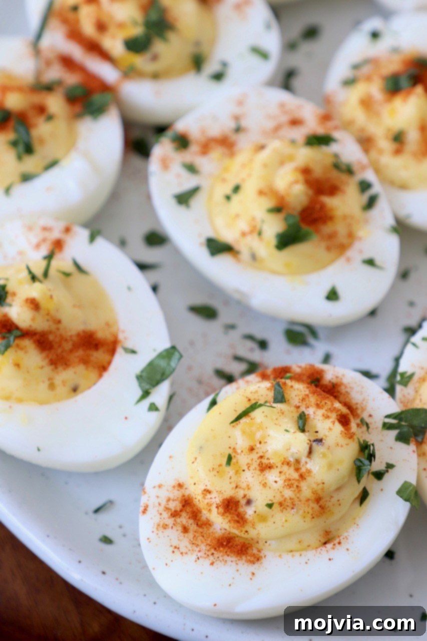 Delicious deviled eggs on a plate, garnished with fresh chopped parsley