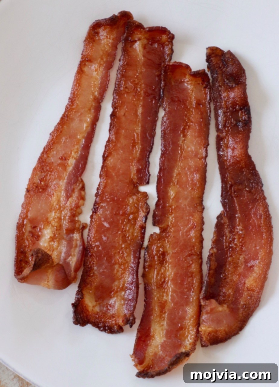 perfectly cooked crispy bacon on a white plate
