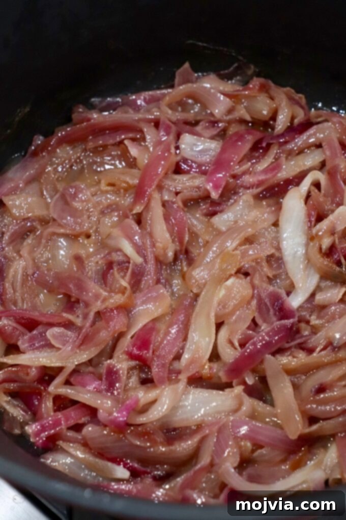 Crafting Irresistible Caramelized Onions 11 Deeply caramelized onions, golden brown and sticky, nearing completion in the cast iron skillet.