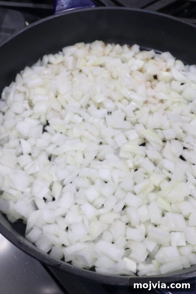Crafting Irresistible Caramelized Onions 12 Diced onions beginning to cook and soften in a large skillet, showing the initial stage of caramelization.