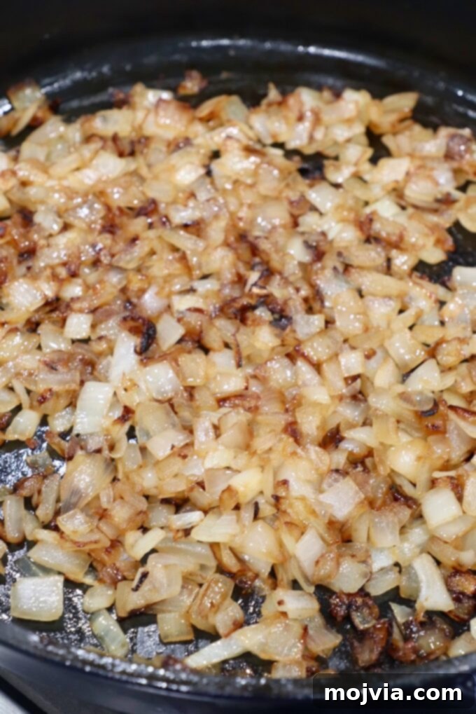 Crafting Irresistible Caramelized Onions 13 A vibrant close-up of diced onions slowly caramelizing to a rich, golden-brown in a hot skillet.