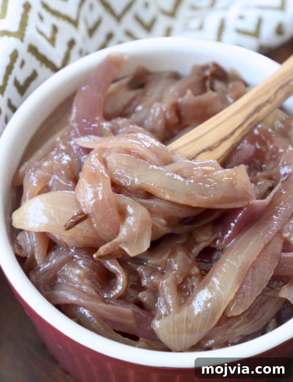 Crafting Irresistible Caramelized Onions 3 A bowl of glossy, amber-hued caramelized onions, with a fork gently resting, inviting a taste.