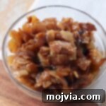 Diced caramelized onions in a small glass bowl, showcasing their irresistible golden hue.