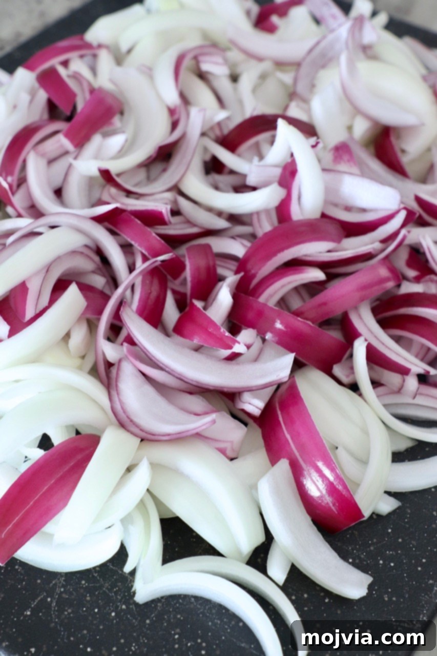 Crafting Irresistible Caramelized Onions 7 Neatly arranged, evenly sliced onions on a clean cutting board, ready for the caramelization process.