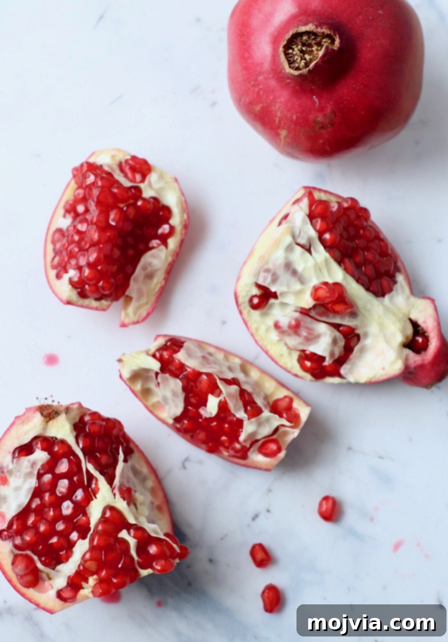 Pomegranate Secrets Revealed 2 pomegranate cut into pieces on white cutting board