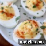 deviled eggs on plate topped with fresh chopped parsley