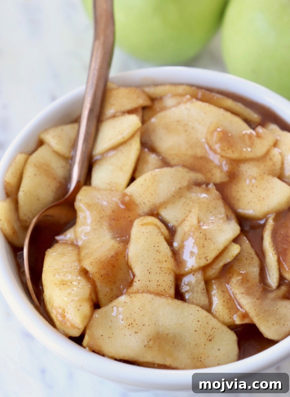 A bowl of rich, golden homemade apple pie filling, ready to be used in delicious desserts.