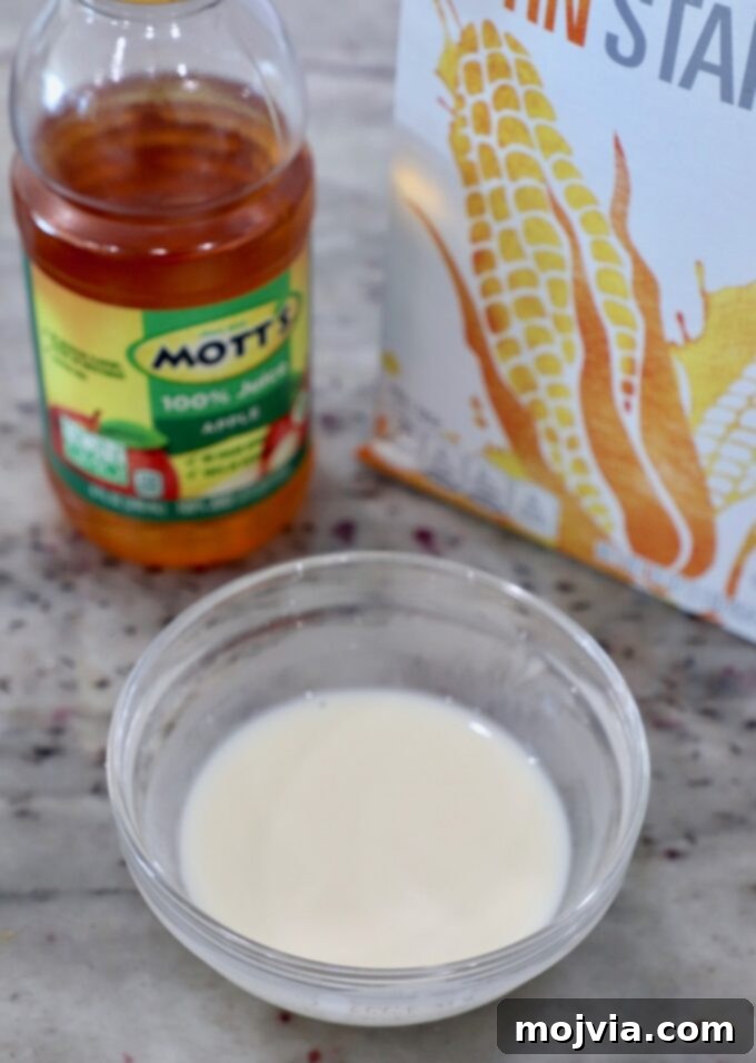 A small glass bowl containing a smooth cornstarch slurry, ready to be added to the apple mixture.