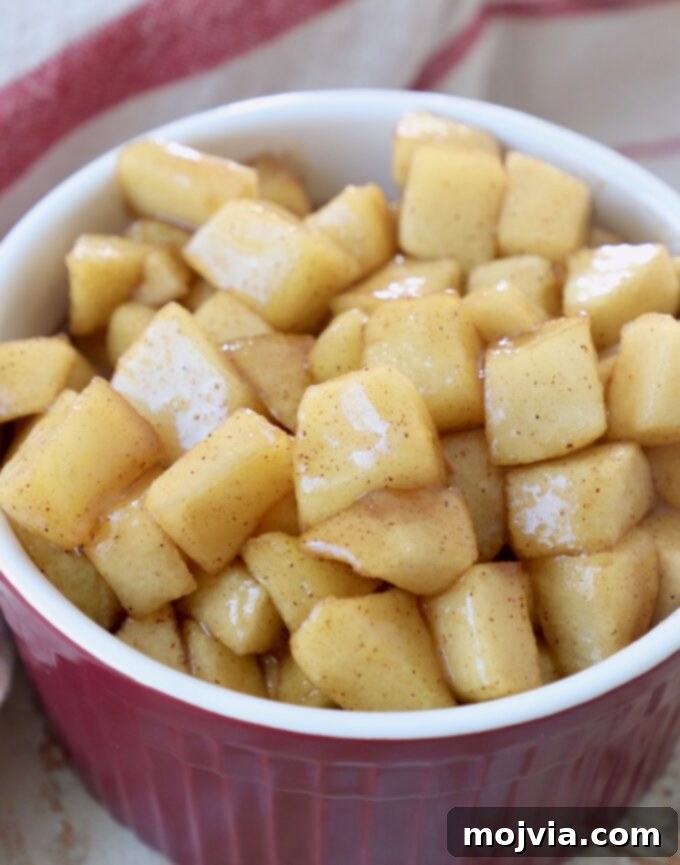 A bowl of cooked apple pie filling with diced apples, showcasing its chunky texture.
