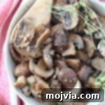 sauteed mushrooms in bowl with wooden spoon