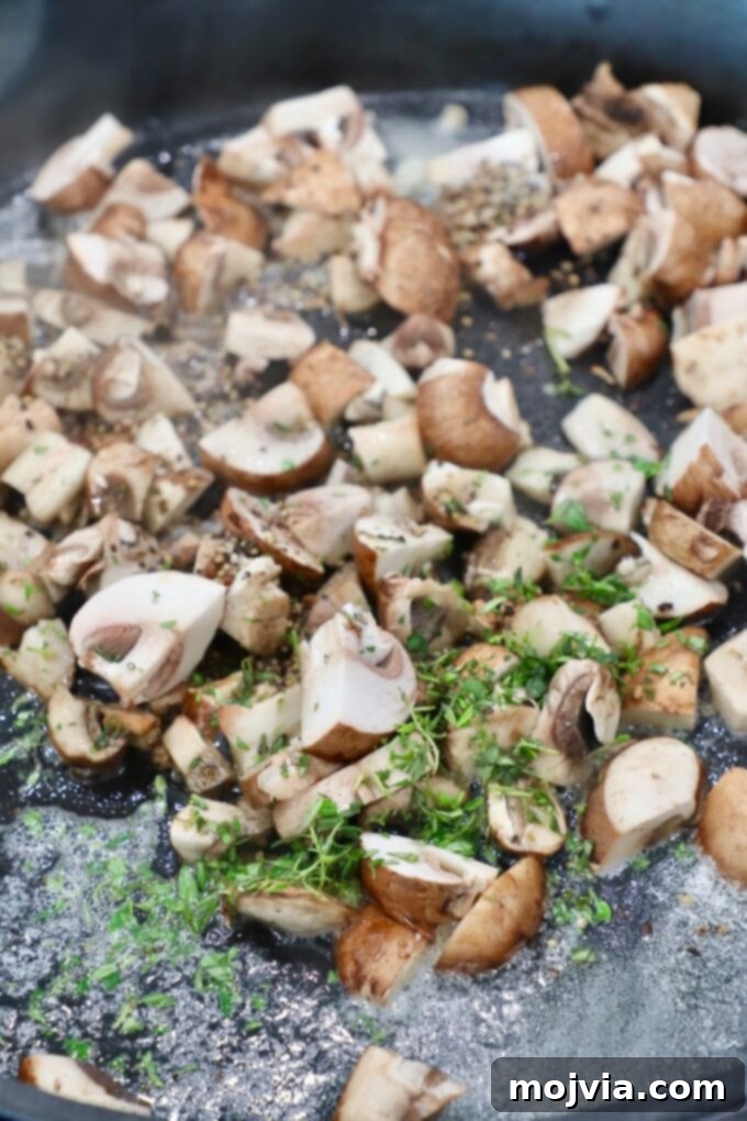Velvety Mushroom Delight 4 Diced mushrooms simmering with fresh thyme in a skillet.