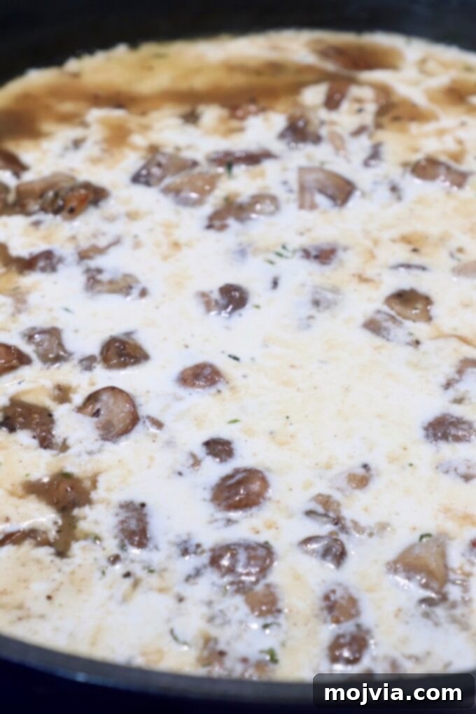 Velvety Mushroom Delight 7 Diced mushrooms in a creamy white sauce simmering in a skillet.