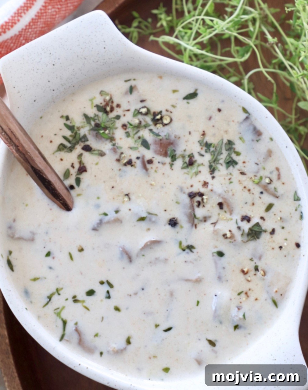 Velvety Mushroom Delight 8 A bowl of hot cream of mushroom soup with a spoon, ready to be enjoyed.