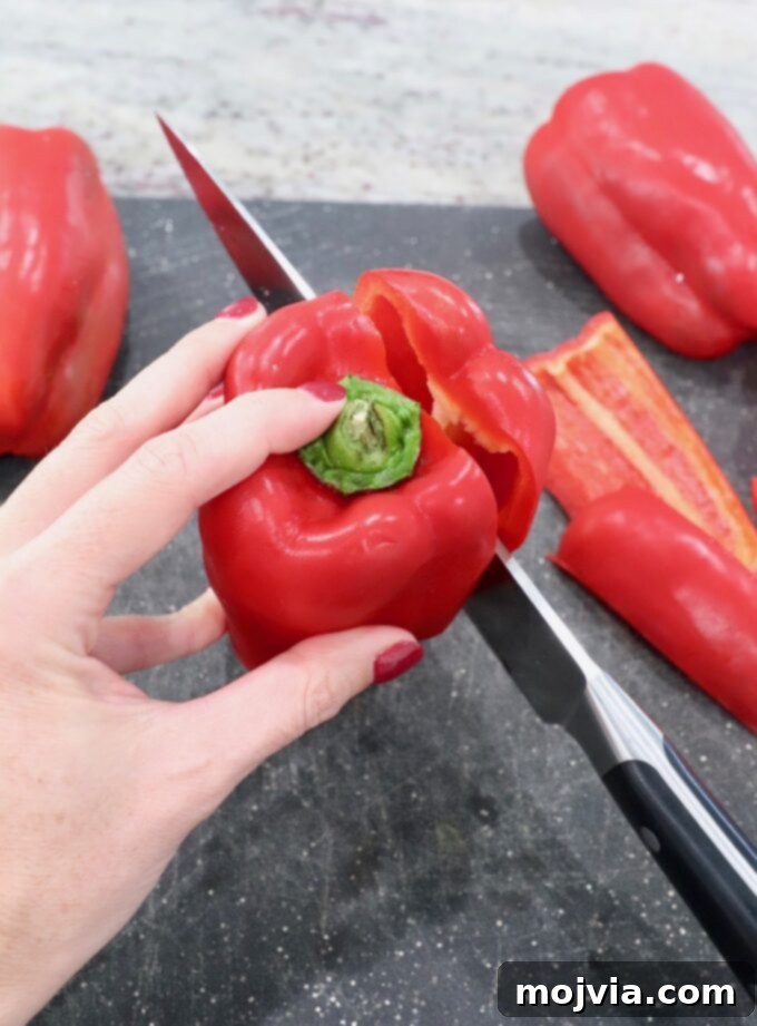 Fire Kissed Red Peppers 3 knife slicing into red bell pepper on cutting board for roasting
