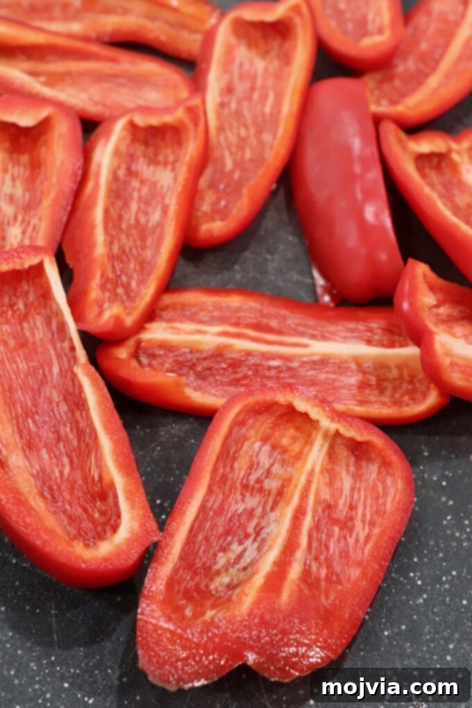 Fire Kissed Red Peppers 4 slices of red bell pepper on cutting board, ready for oven