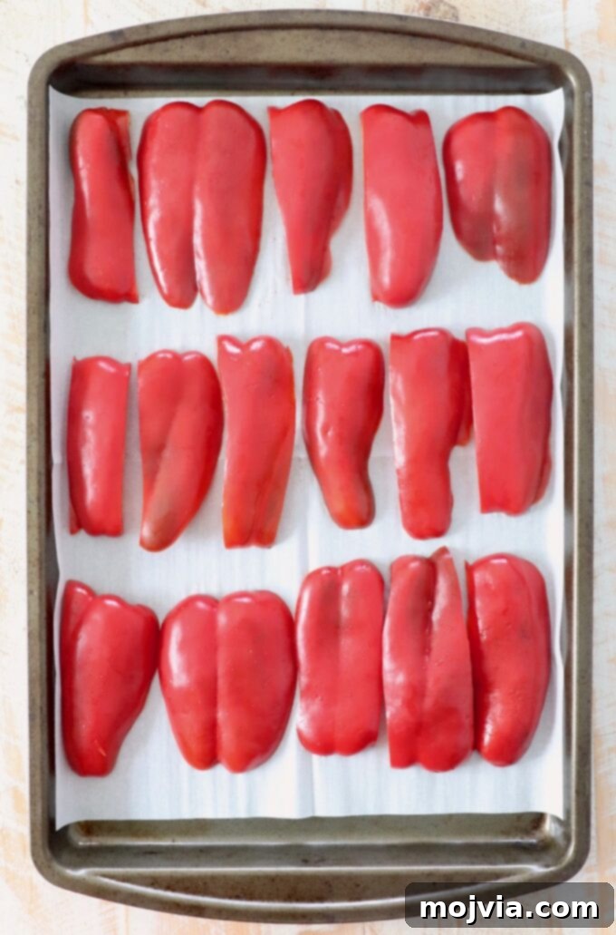 Fire Kissed Red Peppers 5 slices of red bell pepper arranged on parchment lined baking sheet