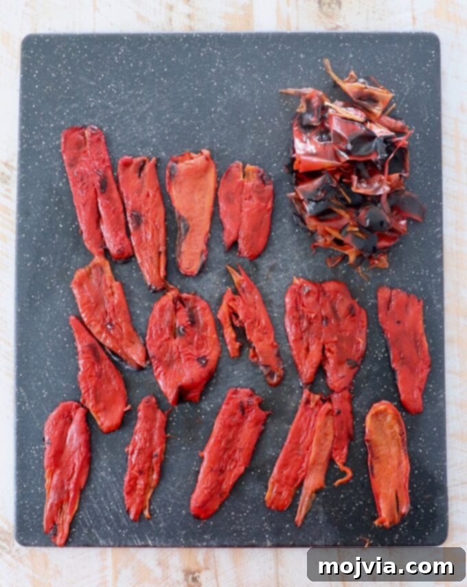 Fire Kissed Red Peppers 8 strips of peeled roasted red peppers on cutting board, ready for use