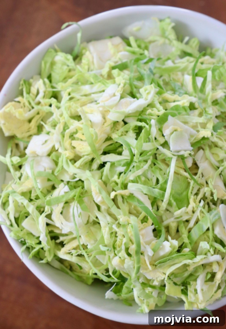 Shredding Brussels Sprouts Made Simple 11 A close-up of a generous serving of freshly shredded Brussels sprouts in a rustic white bowl, ready to be seasoned and served.