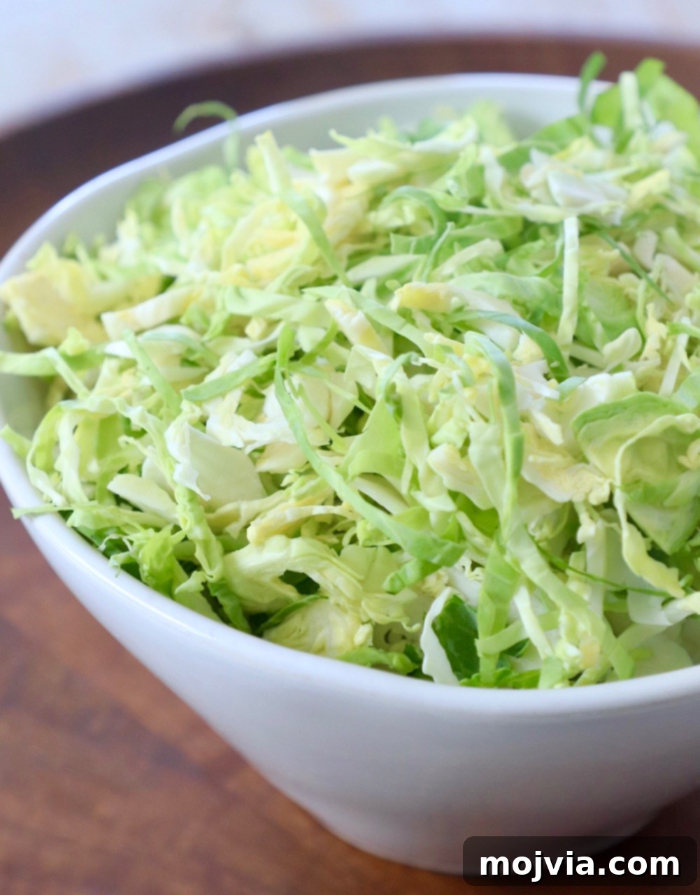 Shredding Brussels Sprouts Made Simple 12 A vibrant display of freshly shredded Brussels sprouts in a rustic white bowl, ready for culinary adventure.