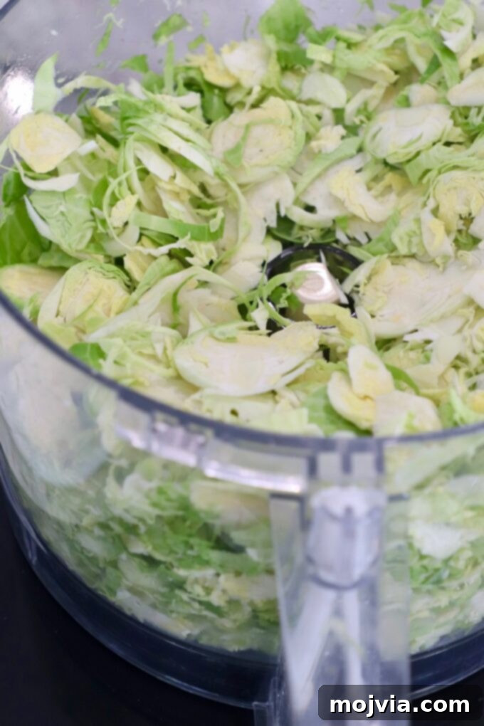Shredding Brussels Sprouts Made Simple 10 A pile of perfectly shredded Brussels sprouts collected in the base of a food processor, demonstrating the efficiency of this method.