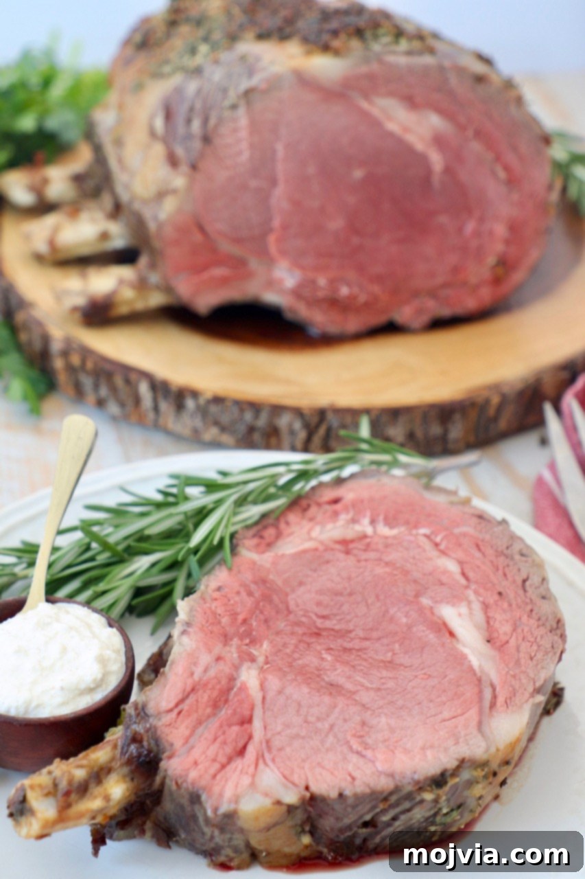 slice of prime rib on the bone on plate and whole prime rib on cutting board behind it
