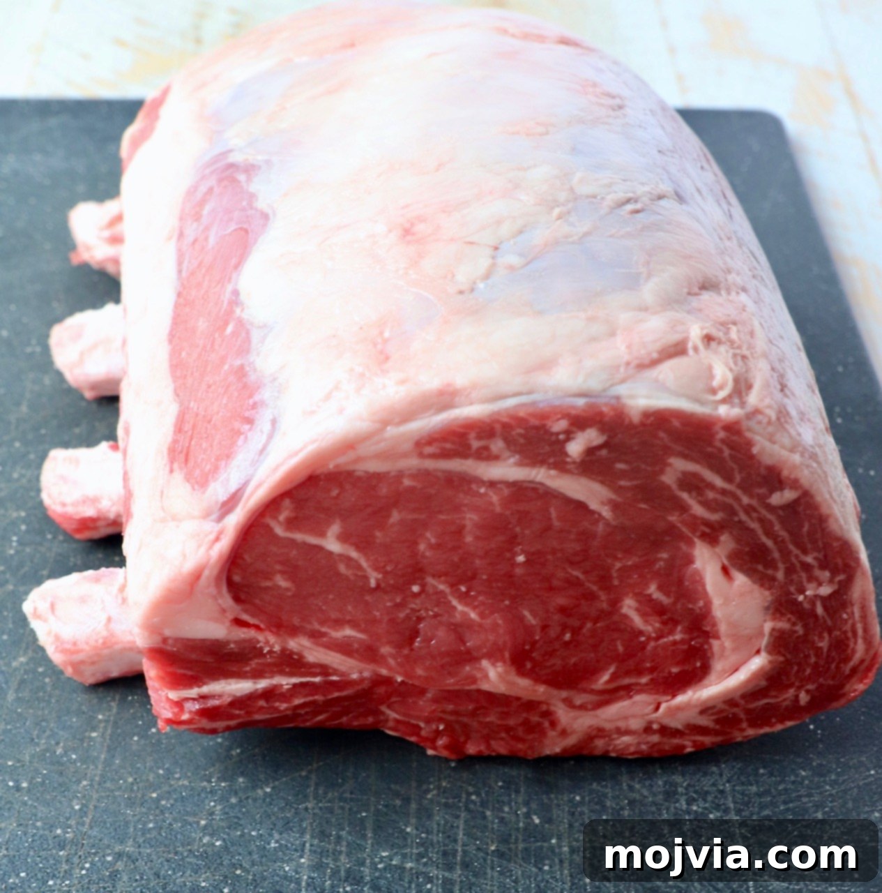 uncooked bone in prime rib on cutting board