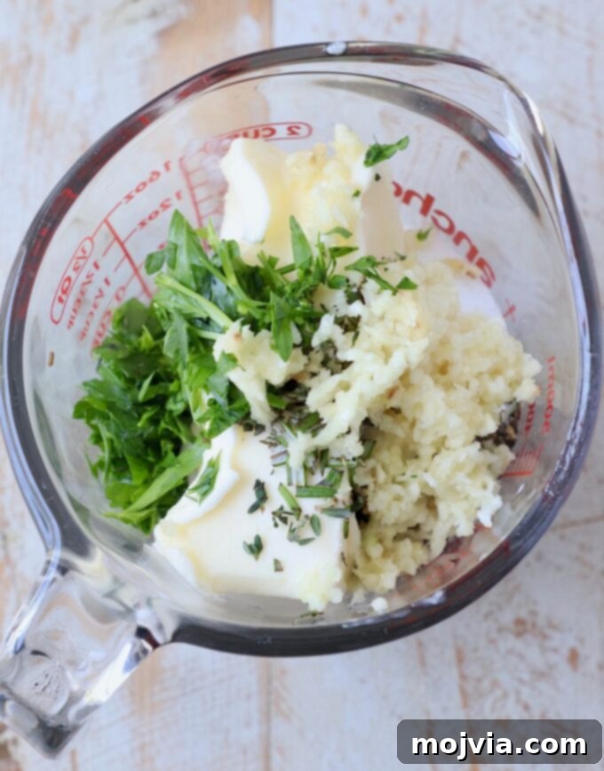 butter, garlic and herbs in glass mixing bowl