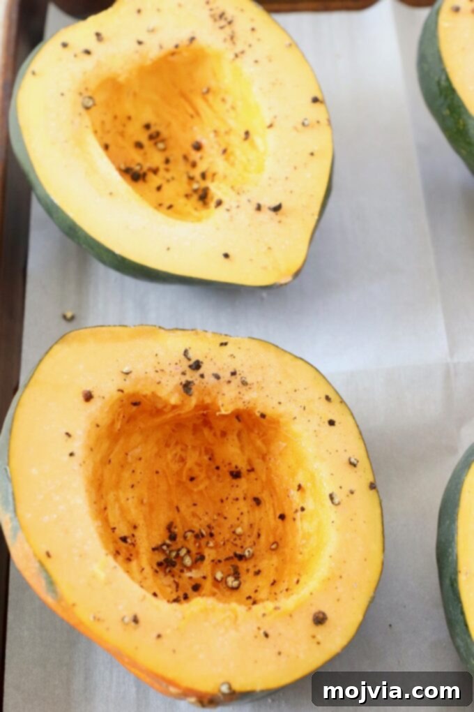 Golden Acorn Squash Comfort 4 Acorn squash cut in half, prepared for roasting on a baking sheet.