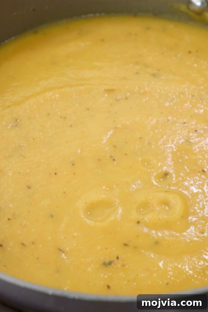 Golden Acorn Squash Comfort 7 Smooth, pureed acorn squash soup in a pot, showcasing its creamy texture.
