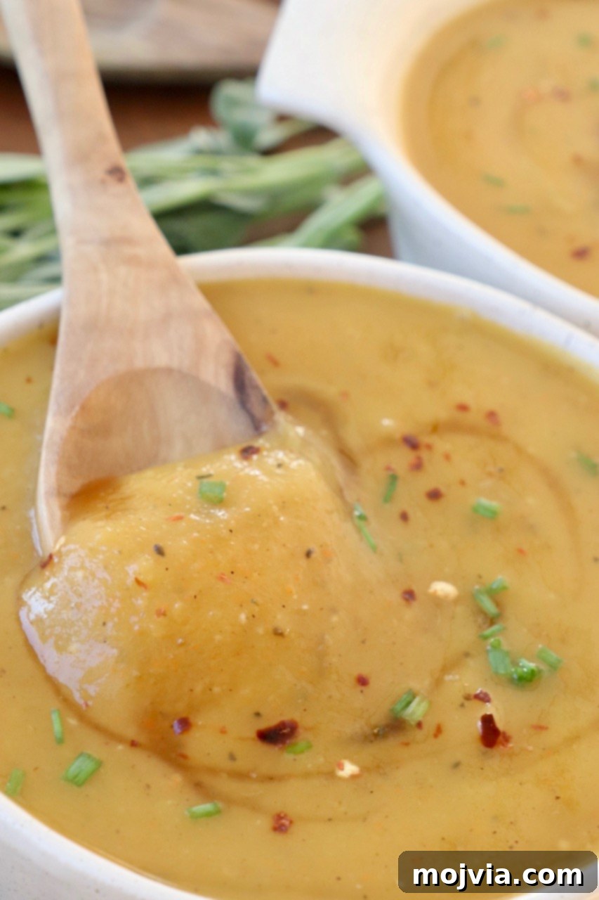 Golden Acorn Squash Comfort 9 A close-up of a bowl of creamy acorn squash soup, perfectly pureed and ready to eat, with a spoon resting in it.