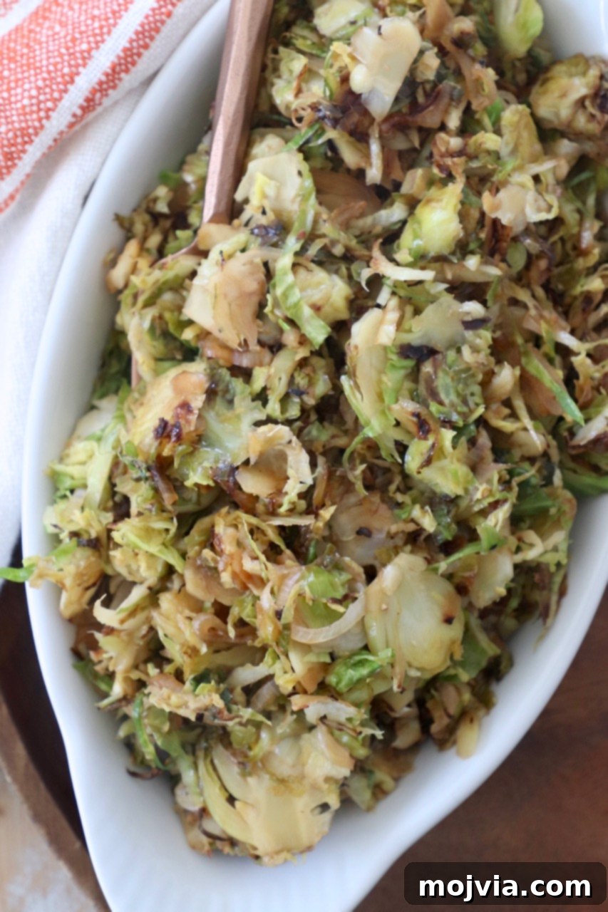 A perfectly cooked serving of caramelized shredded brussels sprouts with a hint of balsamic glaze, presented in a elegant white serving dish.