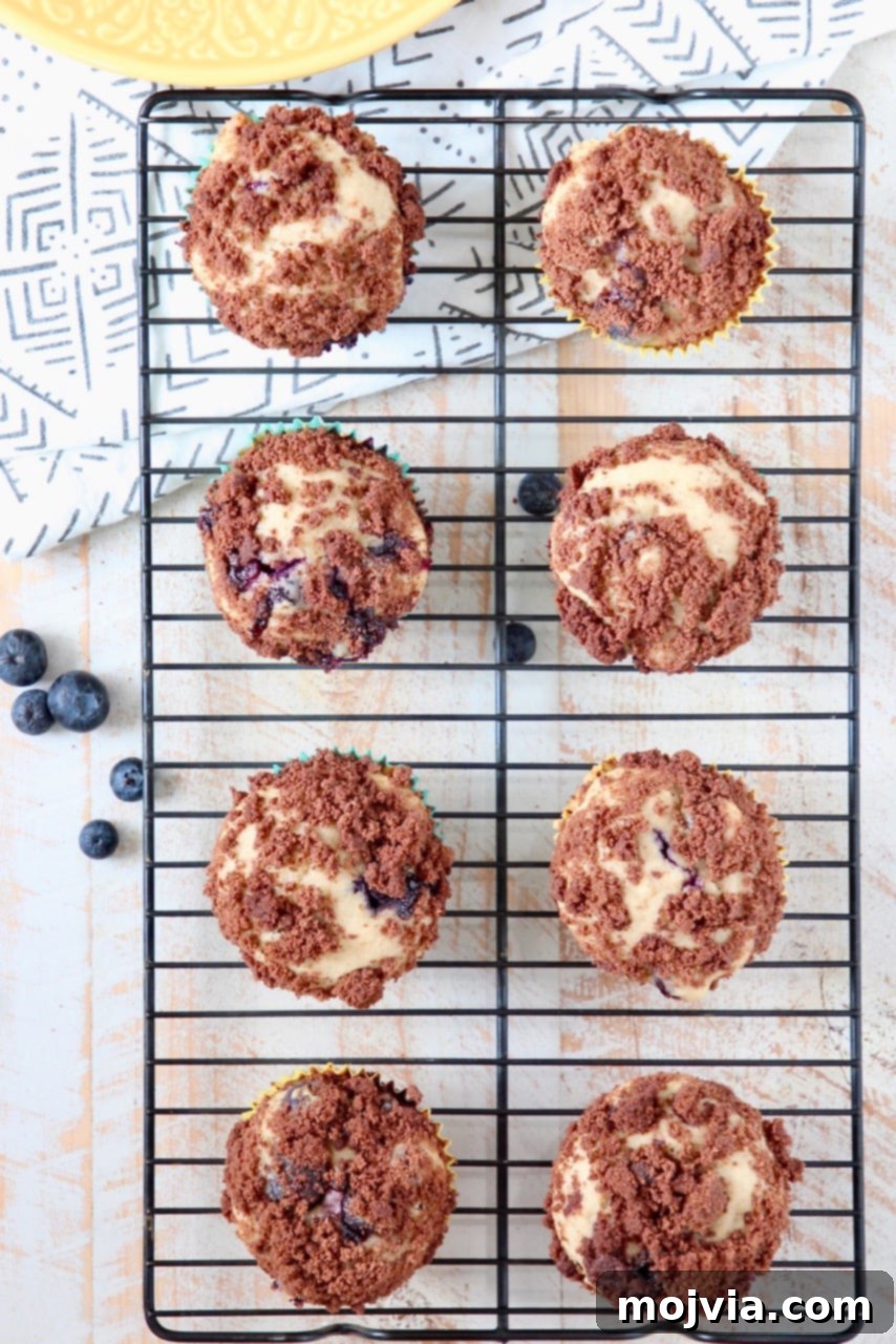 Blueberry Cream Cheese Muffins with Chocolate Crumble cooling on a wire rack