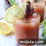 Bloody Mary in glass with lemon wedge and candied bacon