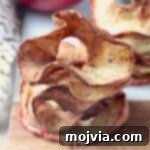 Crispy apple chips stacked on a cutting board, ready to be served.
