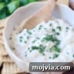 creamy garlic dip in bowl with wooden spoon