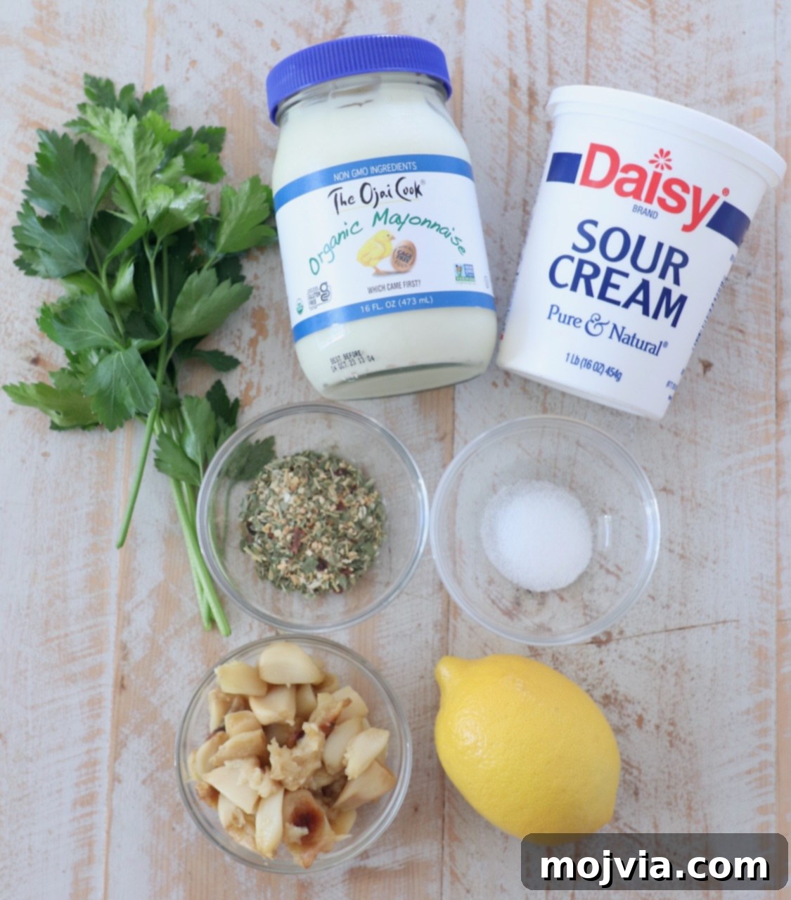 Sweet Roasted Garlic Spread 3 All ingredients for the roasted garlic dip laid out on a white wooden board.