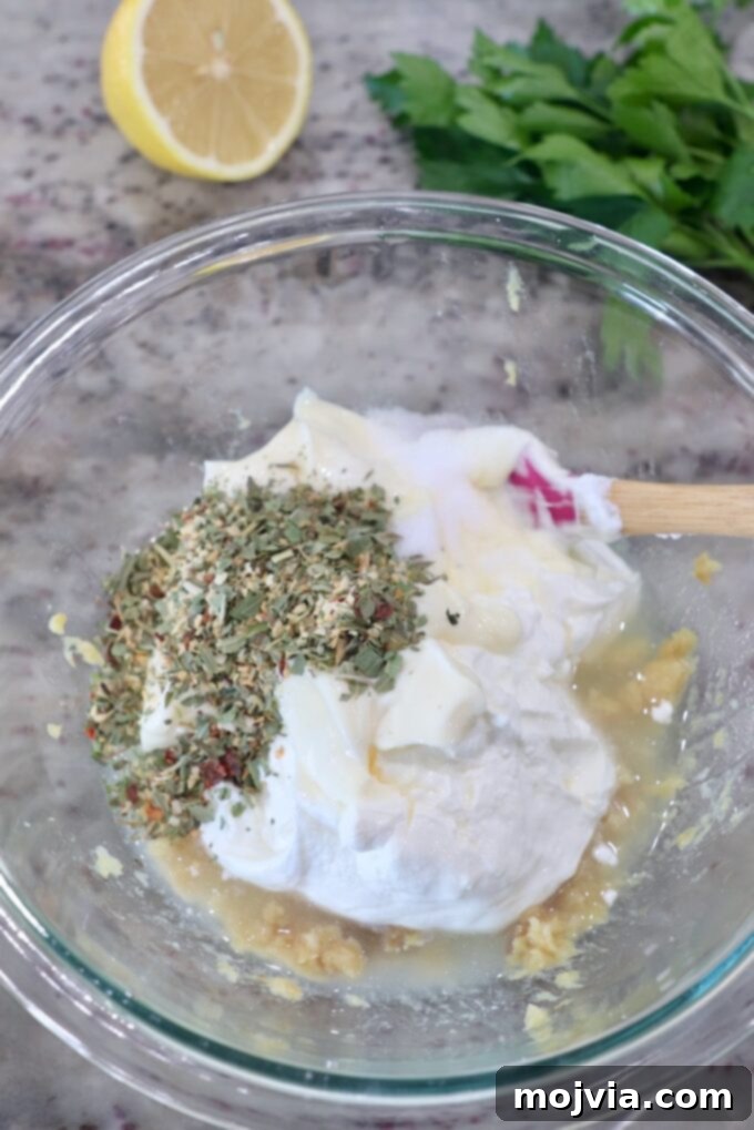Sweet Roasted Garlic Spread 6 All dip ingredients (sour cream, mayonnaise, lemon juice, seasonings) added to the mashed roasted garlic in a glass bowl.