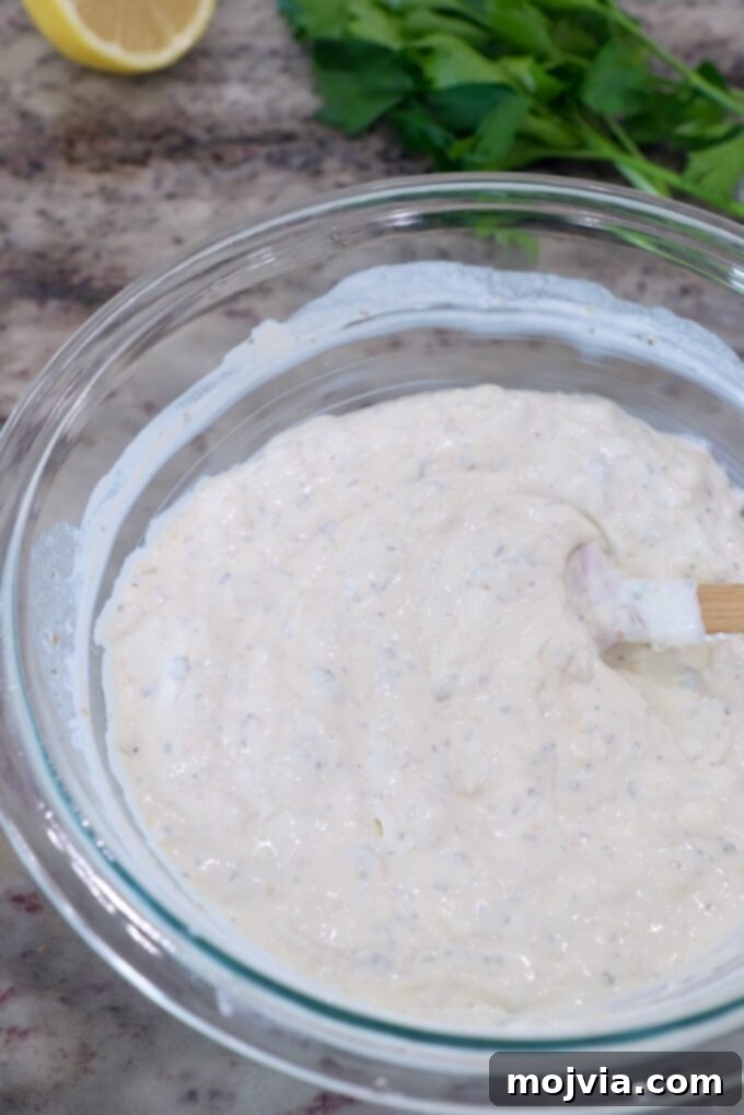 Sweet Roasted Garlic Spread 7 Roasted garlic dip fully mixed in a glass bowl with a spatula, ready to chill.