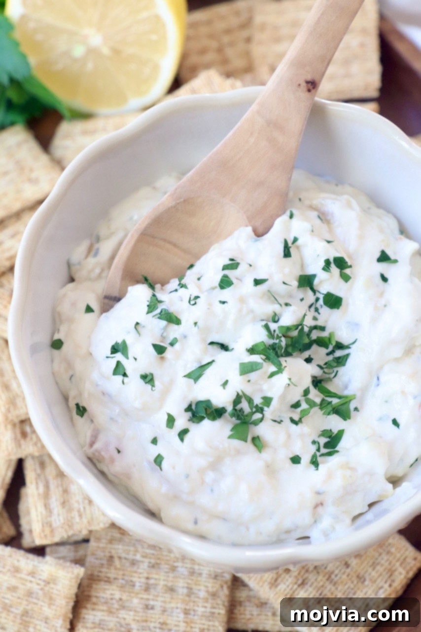 Sweet Roasted Garlic Spread 8 Creamy roasted garlic dip garnished with fresh chopped parsley in a bowl.