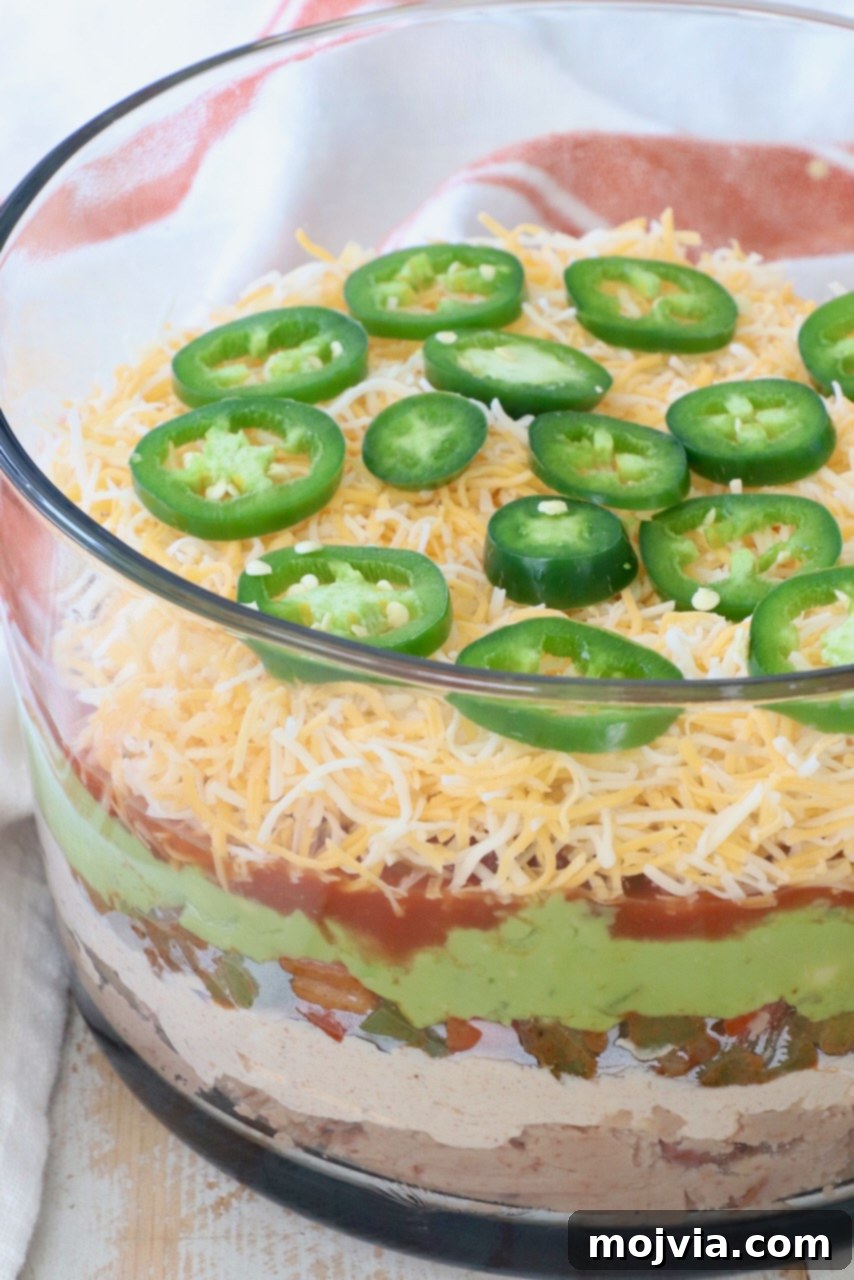 Sizzling Fajita Seven-Layer Dip 2 Flavorful Fajita-Style 7 Layer Dip in a clear glass trifle bowl, ready for serving