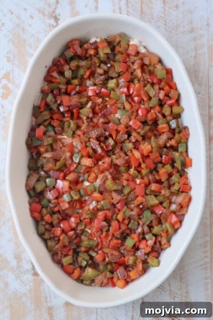 Sizzling Fajita Seven-Layer Dip 8 Diced fajita vegetables added as a vibrant layer in a casserole dish